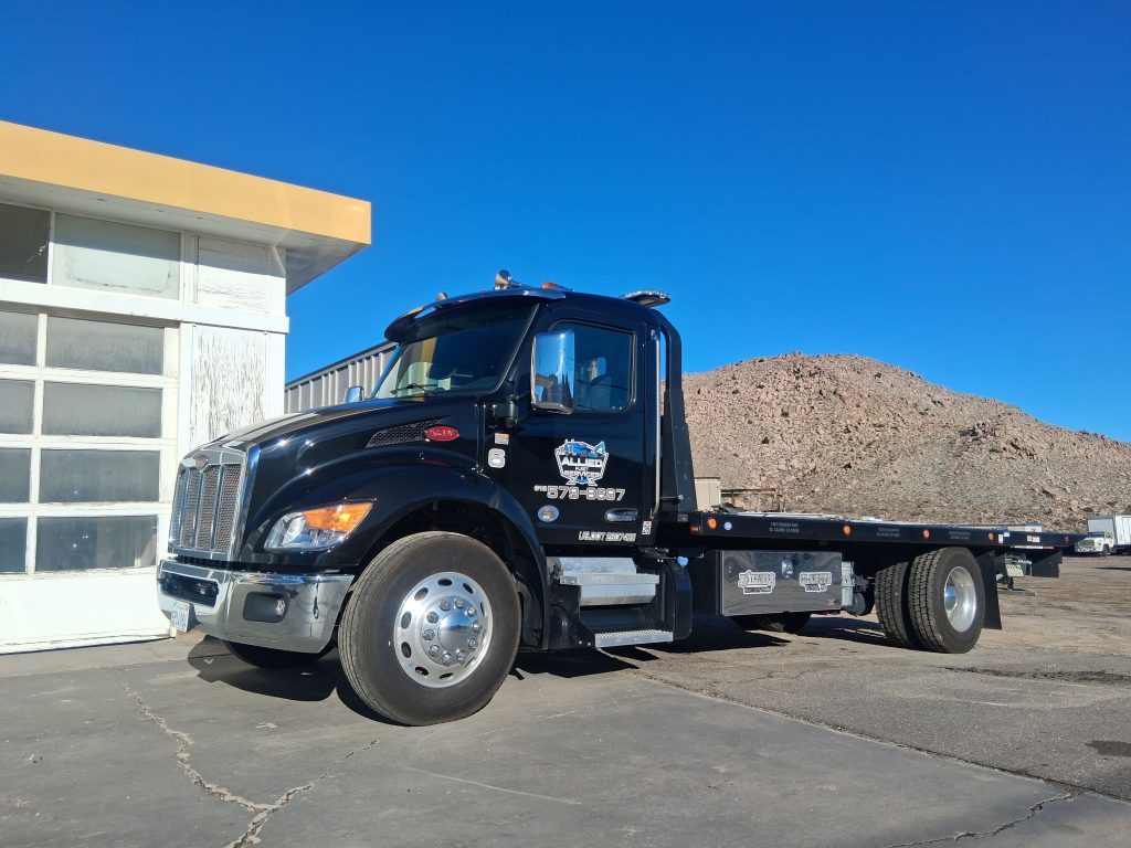 A Miller's In-Ko-Pah Towing flat bed truck in front of the office at 100 In-Ko-Pah Park Road in Jacumba Hot Springs, CA.